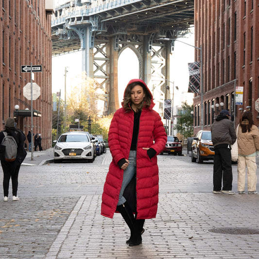 Woman demonstrating how to style a long winter coat in a red puffer.