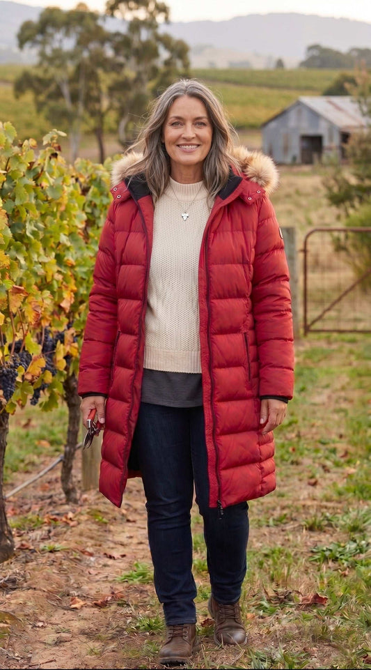 Woman wearing a red puffer coat in Yarra Vallley vineyard setting