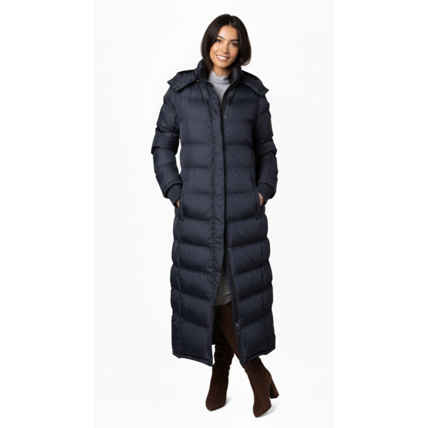 Woman wearing a long navy puffer coat on a white background