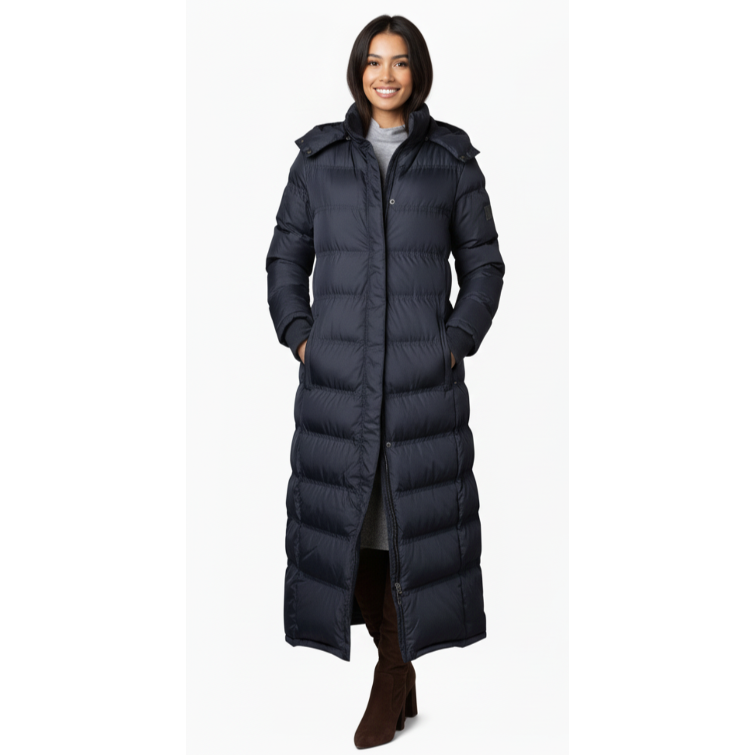 Woman wearing a long navy blue puffer coat on a white background