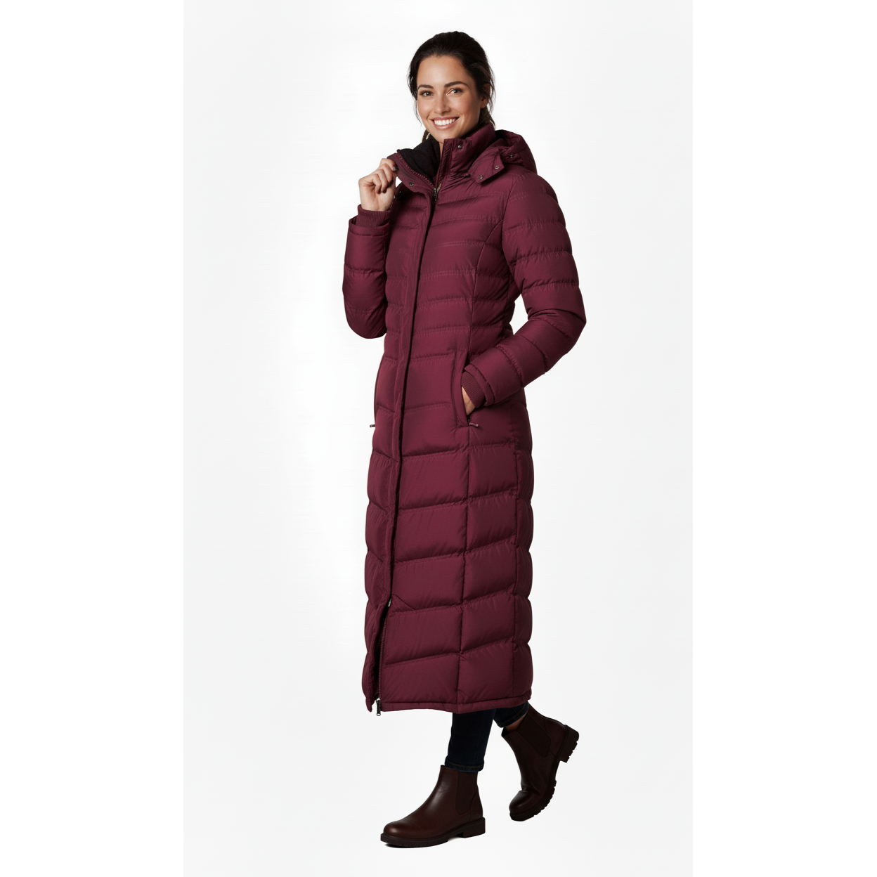 Woman wearing a long burgundy puffer coat on a white background