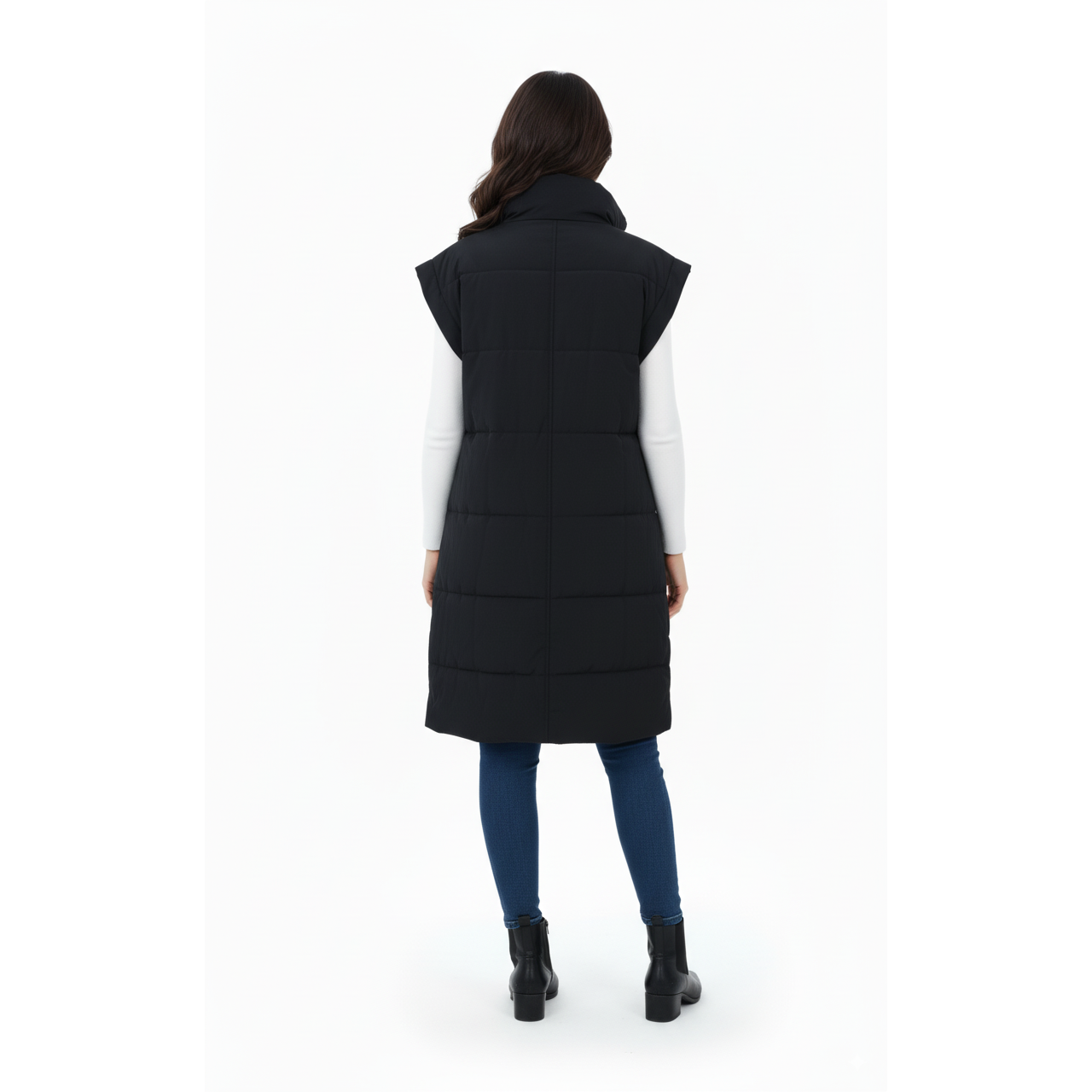 Person wearing a long black puffer vest on a white background