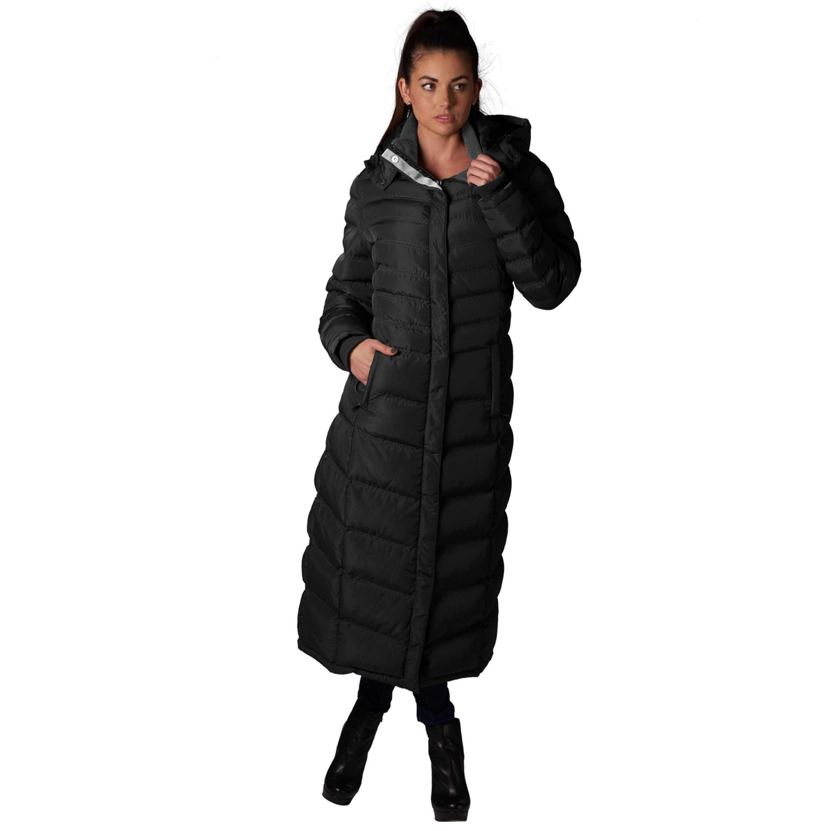 Black full-length puffer coat with quilted design and hood, featuring zippered pockets and long sleeves on a woman.