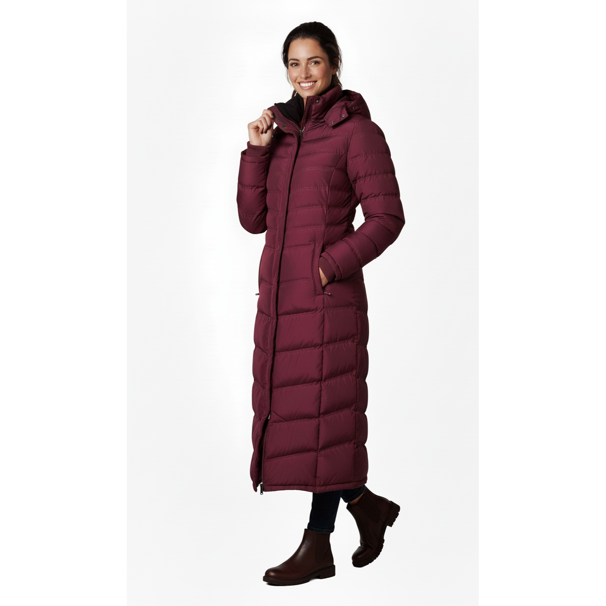 Full-Length Puffer Coat in burgundy with horizontal quilting, high collar, hood, and zippered pockets worn by smiling woman