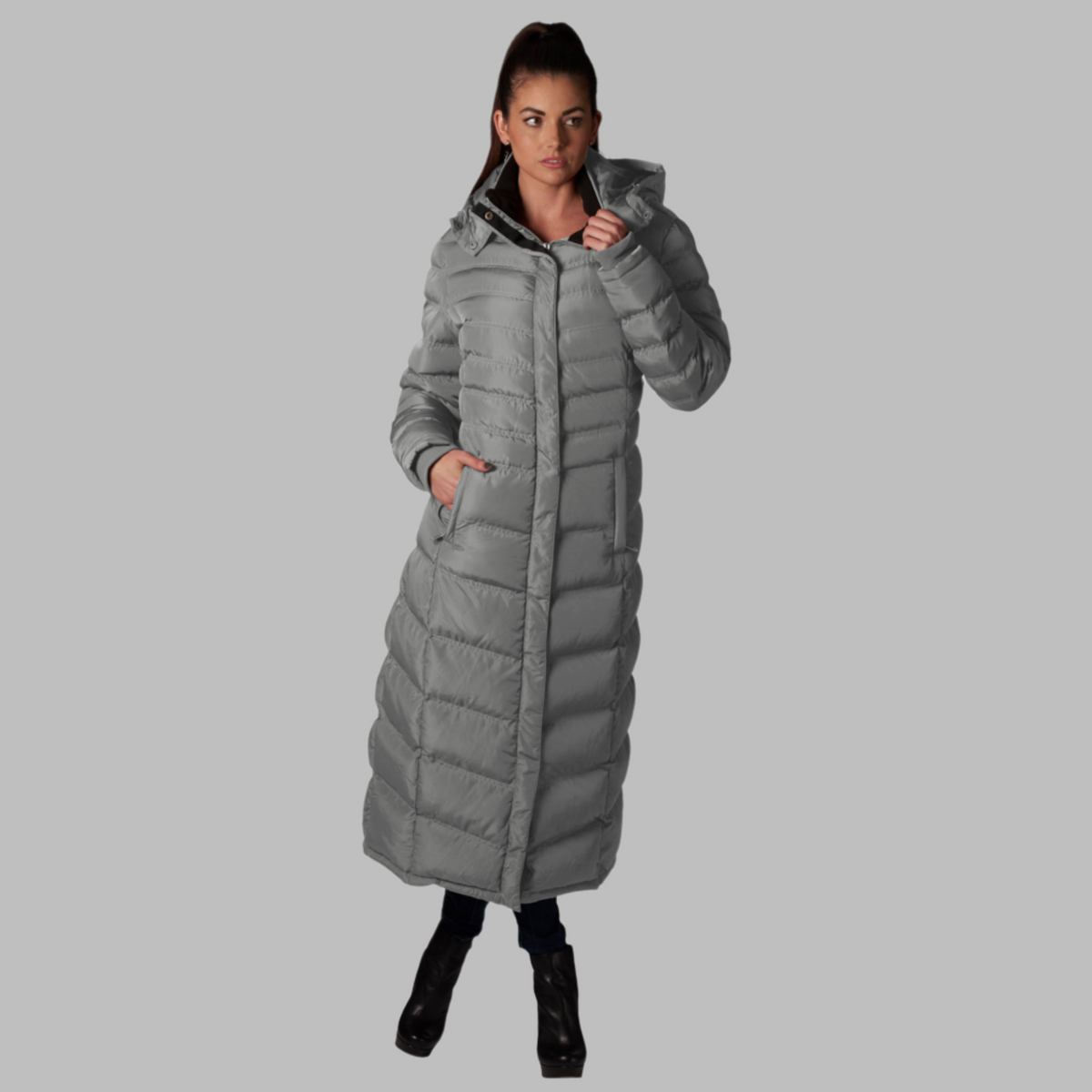 Full-Length Puffer Coat in light grey with quilted pattern, full length, hood, and zippered pockets worn by a woman