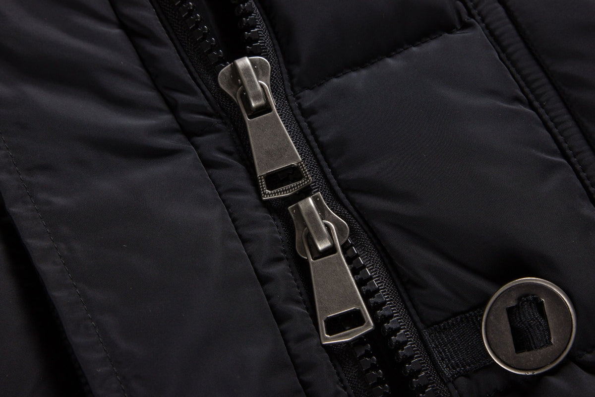 Black ELORA 2566 parka close-up showing both two-way zipper sliders and a round metal button.